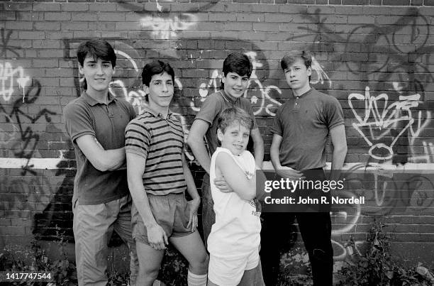 Portrait of the members of American vocal pop group New Kids on the Block as they pose against a graffiti-covered brick wall, Boston, Massachusetts,...