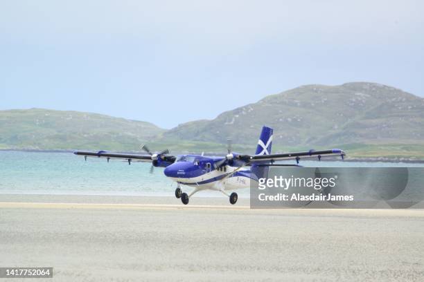 loganair twin otter taking off on barra beach airport - barra scotland stock pictures, royalty-free photos & images