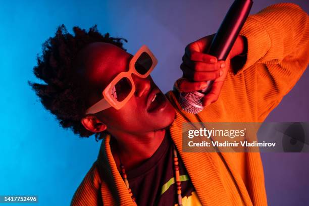 enthusiastic man singing into a microphone - mike glad stockfoto's en -beelden
