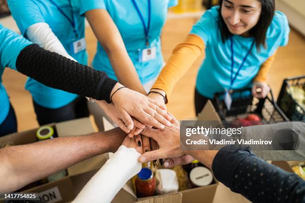 diverse people stacking hands together - philanthropist 個照片及圖片檔