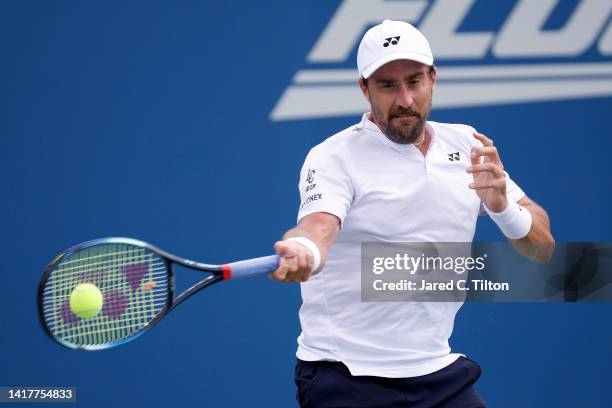 Steve Johnson returns a shot from Richard Gasquet of France during their third round match on day five of the Winston-Salem Open at Wake Forest...