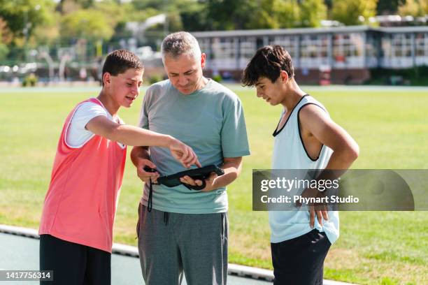 coach talking to the teenage boys athletes - sprint planning stock pictures, royalty-free photos & images