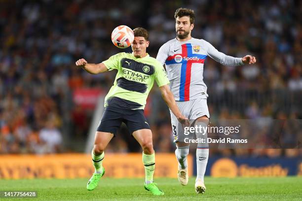 Julian Alvarez of Manchester City is challenged by Gerard Pique of FC Barcelona during the friendly match between FC Barcelona and Manchester City at...