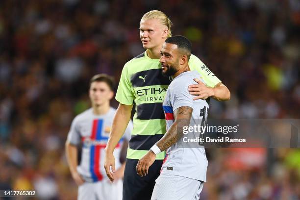 Erling Haaland of Manchester City and Memphis Depay of FC Barcelona embrace after the friendly match between FC Barcelona and Manchester City at Camp...