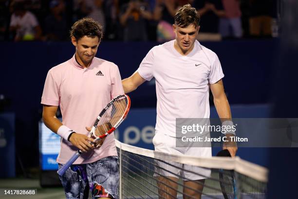 Jack Draper of Great Britain and Dominic Thiem of Austria meet at the net following their third round match on day five of the Winston-Salem Open at...