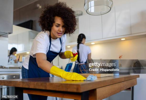 professional cleaner cleaning a table at a house - janitorial services stockfoto's en -beelden