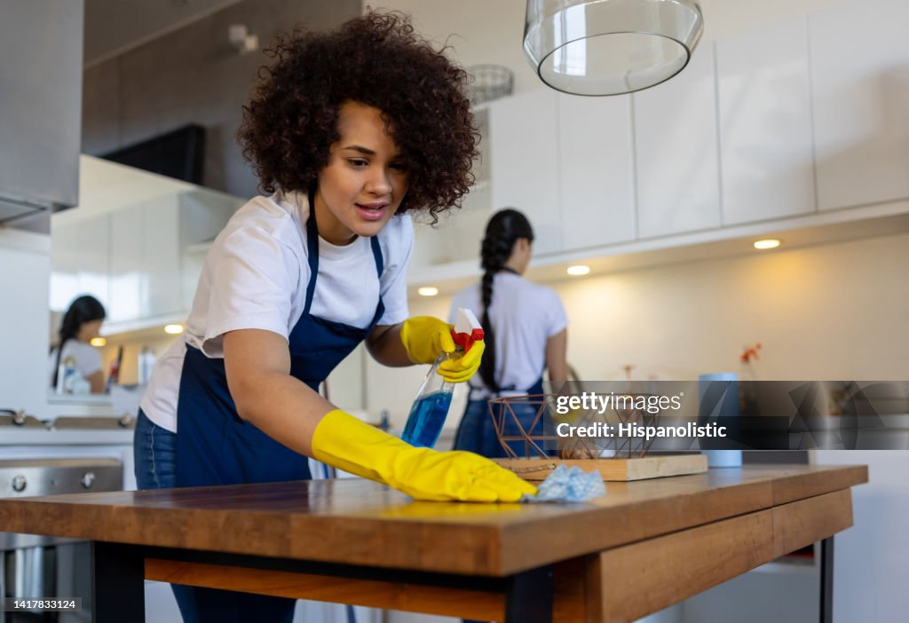 Professional cleaner cleaning a table at a house