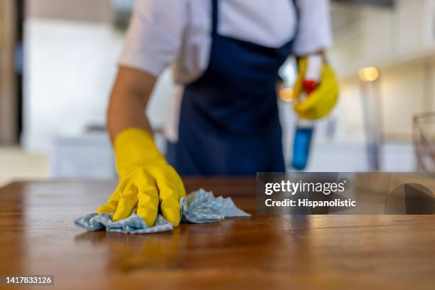 close-up on a professional cleaner cleaning a table at a house - schoonmaken stockfoto's en -beelden