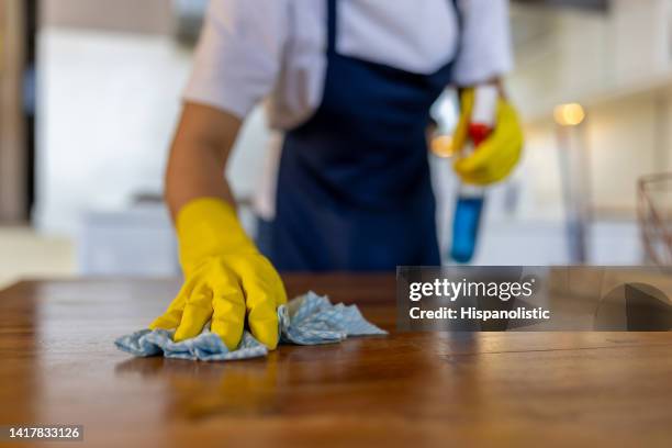 close-up on a professional cleaner cleaning a table at a house - janitorial services stockfoto's en -beelden