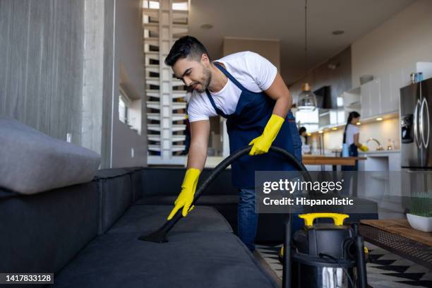 nettoyeur professionnel passant l’aspirateur sur un canapé - monsieur propre photos et images de collection