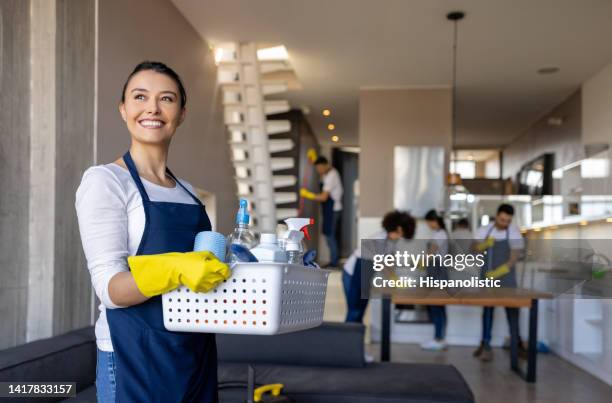 professional cleaner working with her team cleaning a house - janitorial services stockfoto's en -beelden