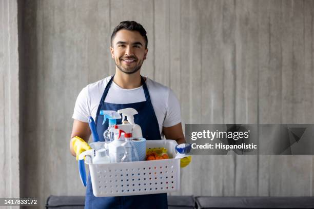 professioneller reiniger, der einen korb mit reinigungsmitteln hält - cleaner man uniform stock-fotos und bilder