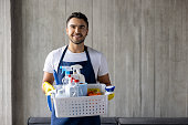 Professional cleaner holding a basket of cleaning products