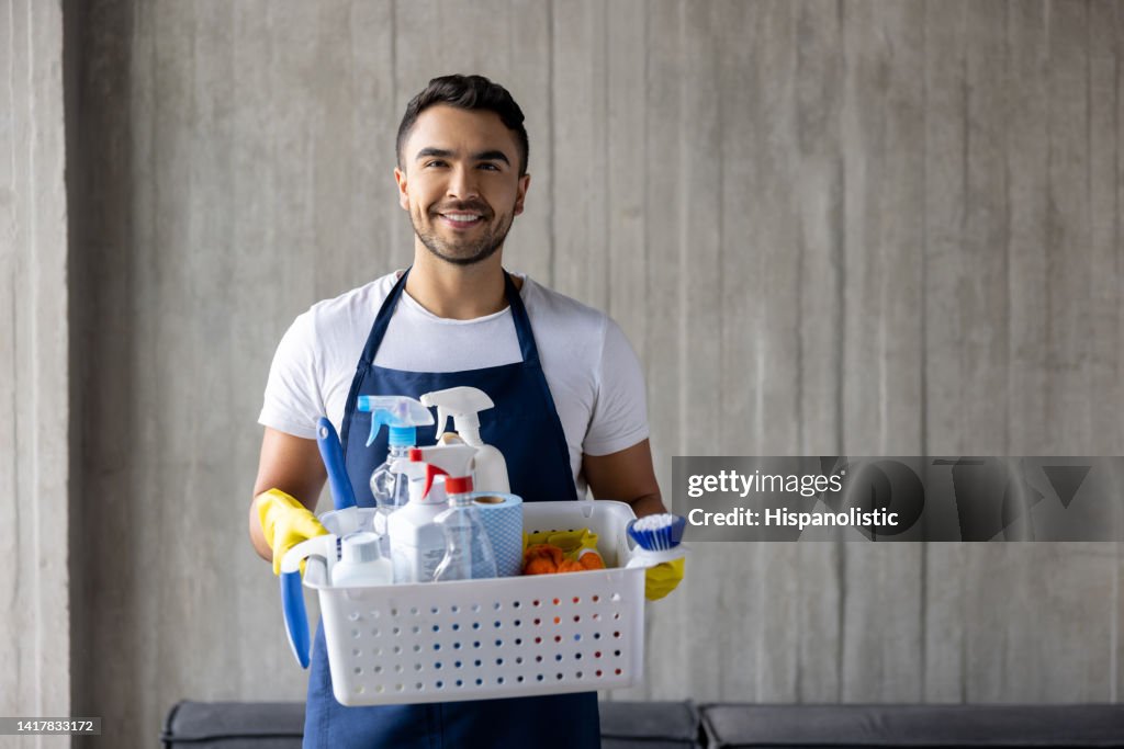 Limpador profissional segurando uma cesta de produtos de limpeza