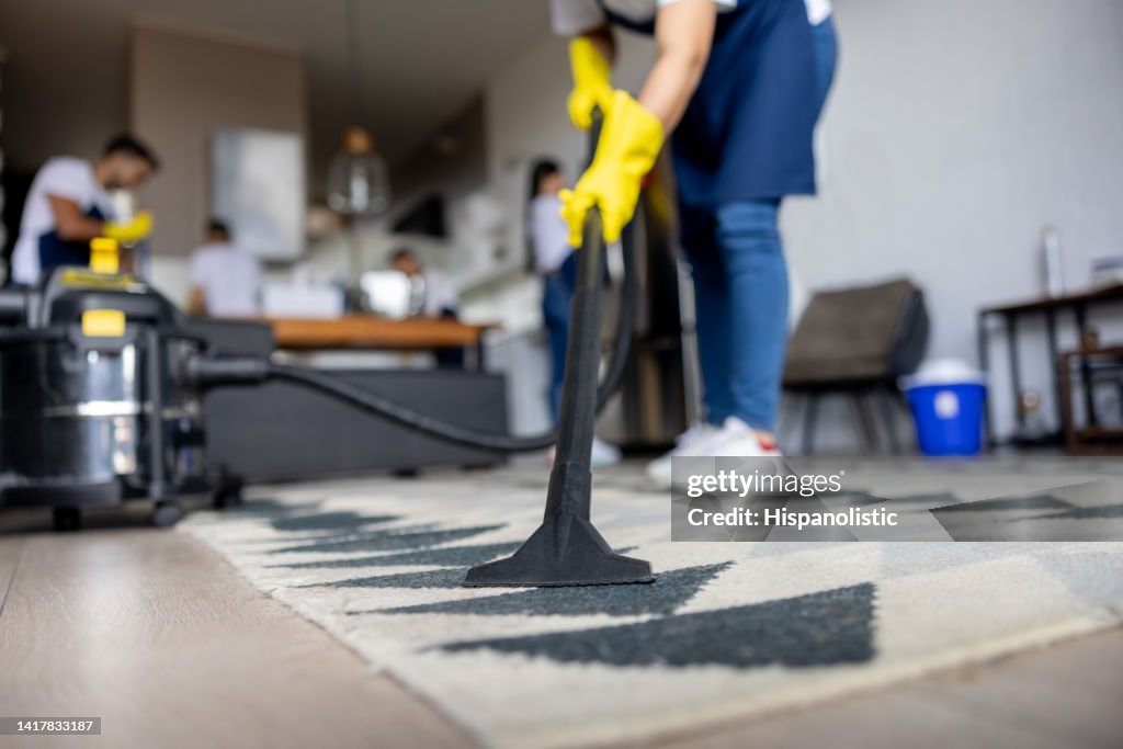 Professioneller Reiniger saugt einen Teppich
