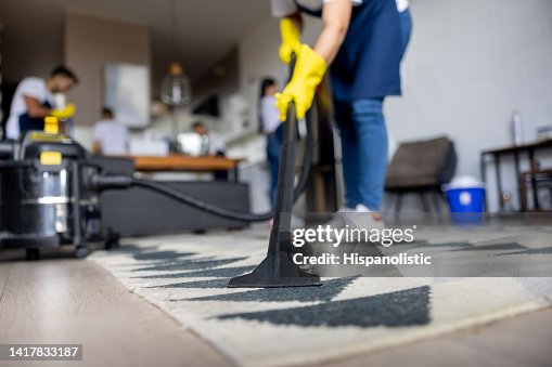 Professional cleaner vacuuming a carpet Professional cleaner vacuuming a carpet