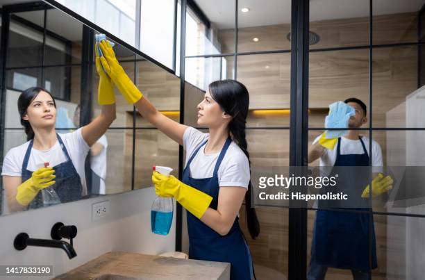 team of professional cleaners cleaning the bathroom at an apartment - professional cleaner stock pictures, royalty-free photos & images