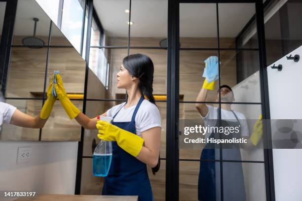 team of professional cleaners cleaning the bathroom - cleaner man uniform stock pictures, royalty-free photos & images