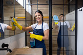 Happy professional cleaners cleaning a bathroom at an apartment