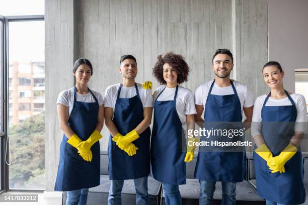 happy group of professional cleaners working at an apartment - cleaning crew stock pictures, royalty-free photos & images