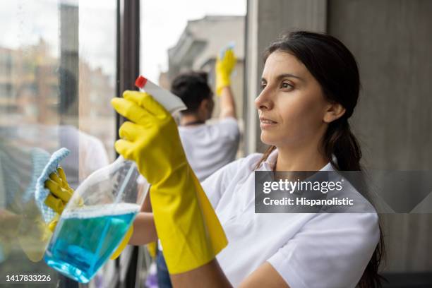 team von professionellen reinigungskräften, die die fenster einer wohnung reinigen - window cleaner stock-fotos und bilder