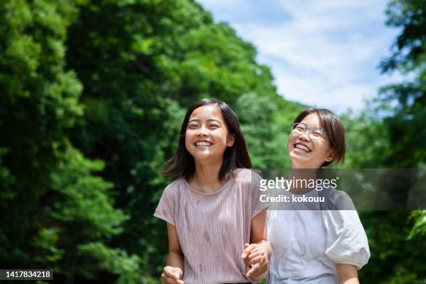 2人のティーンエイジャーが楽しく遊び、自然の中で微笑む - 若い カワイイ 女の子 日本人 ストックフォトと画像