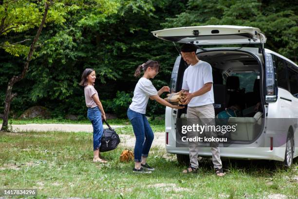 a father and his two daughters prepare to build a tent at a campsite. - car camping luggage stock pictures, royalty-free photos & images