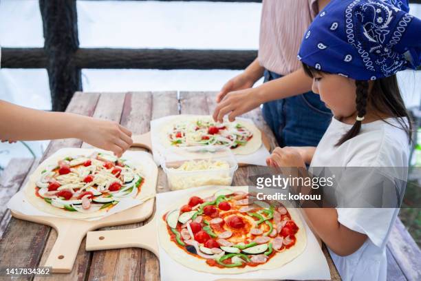 three girls having fun making pizza - making pizza stock pictures, royalty-free photos & images