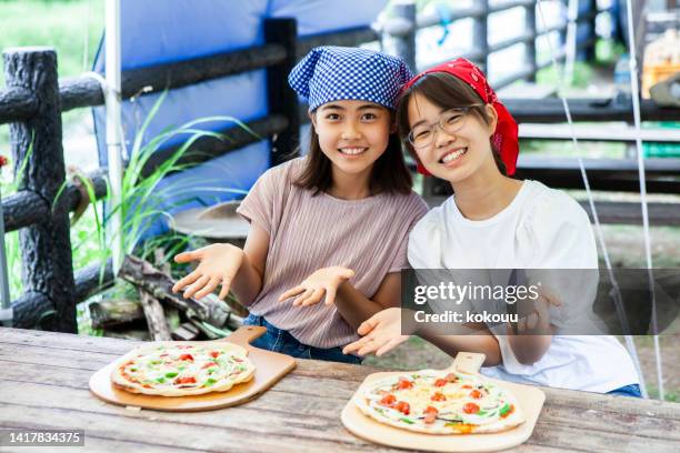 portrait of teenage girls showing their cooking - children cooking school stock pictures, royalty-free photos & images