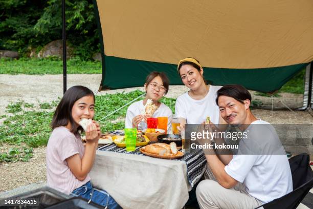 キャンプ場のテントで食事をする美しい家族の肖像画 - アウトドア　日本人 ストックフォトと画像