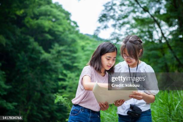 sisters looking at the map in the nature park - girl hiking stock pictures, royalty-free photos & images