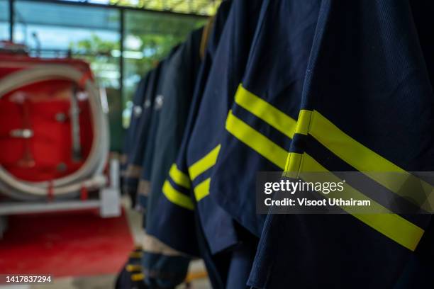 firefighters' uniforms inside fire station,firefighter suit and equipment ready for operation. - military uniform hanging stock pictures, royalty-free photos & images