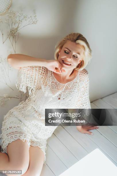 young woman in lace clothing on wood floor. - blonde wood texture stockfoto's en -beelden