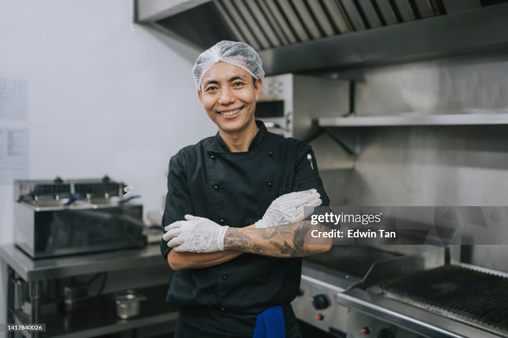 Asian Kitchen male crew helper looking at camera smiling