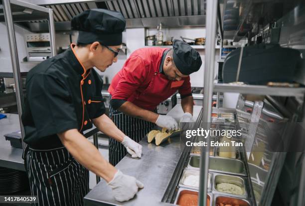 asian chinese male trainee kitchen crew learning from master chef preparing taco mexican food in commercial kitchen - chef perfection stock pictures, royalty-free photos & images