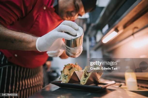 chef indien asiatique préparant des tacos mexicains dans la cuisine - préparation des aliments photos et images de collection