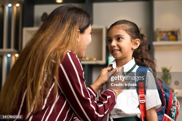 mother getting her daughter ready in school uniform at home - school uniform stock pictures, royalty-free photos & images