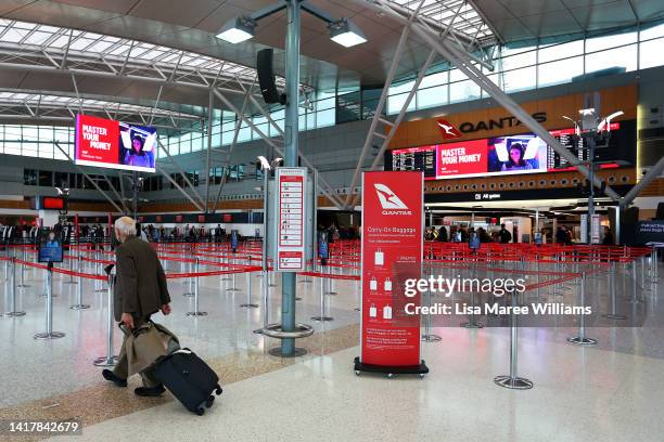 Traveller arrives to check-in at the Qantas domestic terminal at Sydney Airport on August 25, 2022 in Sydney, Australia. Qantas Group posted a loss...