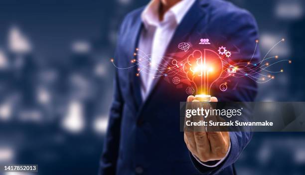 innovation. new concept ideas with innovations hand in hand with future lamp technology and inspiration in science and communication concepts. - new discovery stock pictures, royalty-free photos & images