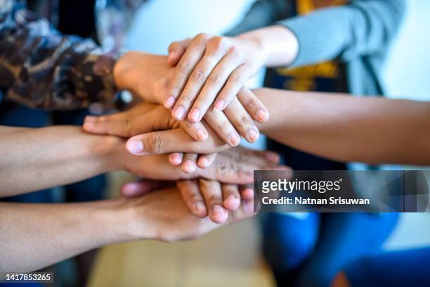 group of asian business people stacking hands in office - hand stack stock pictures, royalty-free photos & images