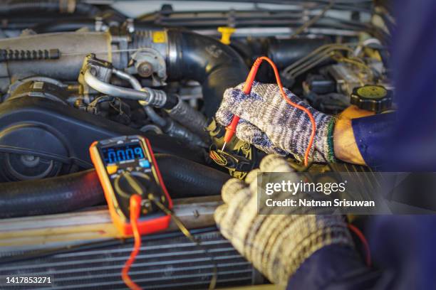 professional mechanic working on the engine of the car in the garage. car repair service. the concept of checking the readiness of the car before leaving. - racing garage stock pictures, royalty-free photos & images