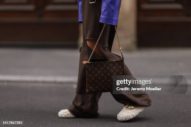 Sonia Lyson is seen wearing Louis Vuitton monogramm brown clutch bag, Nakd fur slipper, Prada brown shades, Storets brown destroyed wide leg jogging...