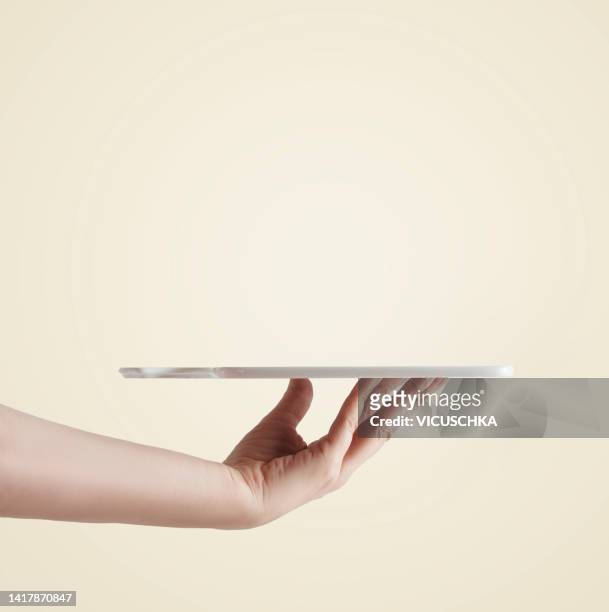 women hand holding empty tray at light background. - vassoio foto e immagini stock
