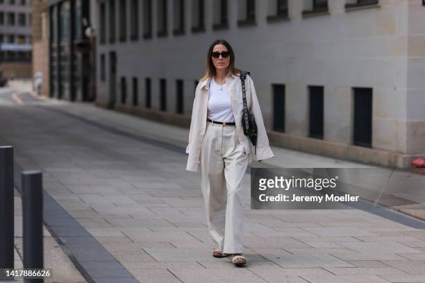 Elise Seitz seen wearing black sunglasses, a white tank top, gold pearl necklace, a beige SohoStudios shirt, black leather Celine Triomphe belt,...