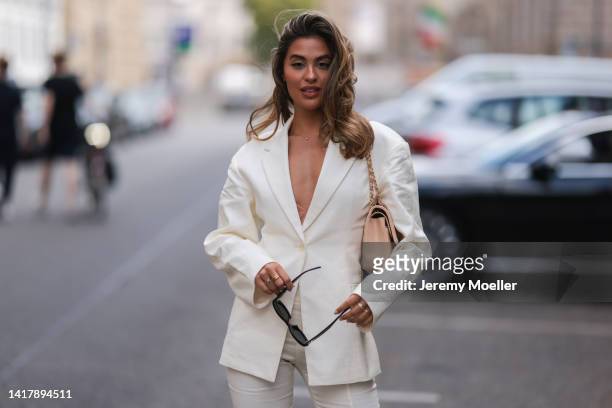Jessica de Oliveria is seen wearing Chanel beige leather flapbag, Jacquemus matching linen blazer and suit pants, Celine black round shades and beige...
