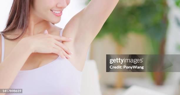 girl touching her armpit - hair removal stockfoto's en -beelden