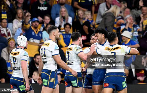 Mitchell Moses of the Eels is congratulated by team mates after scoring a try during the round 24 NRL match between the Brisbane Broncos and the...