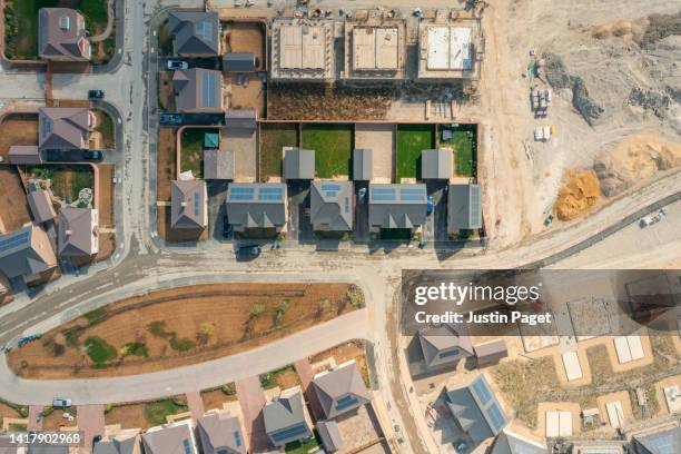 drone view of a new housing development still under construction, with building at various different stages. some are occupied - building foundations stock pictures, royalty-free photos & images