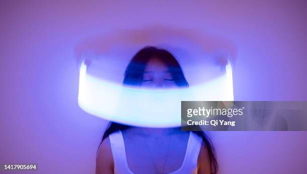 front view of young asian woman standing on holographic background. metaverse and ai - portrait blurred background stockfoto's en -beelden
