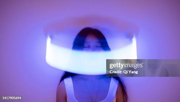 front view of young asian woman standing on holographic background. metaverse and ai - long exposure face stock pictures, royalty-free photos & images